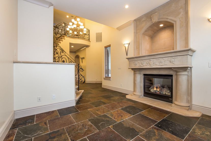 spacious living room with a magnificent spiral staircase, gorgeous tile flooring, and high ceilings in an Invitation Homes property in Northern CA