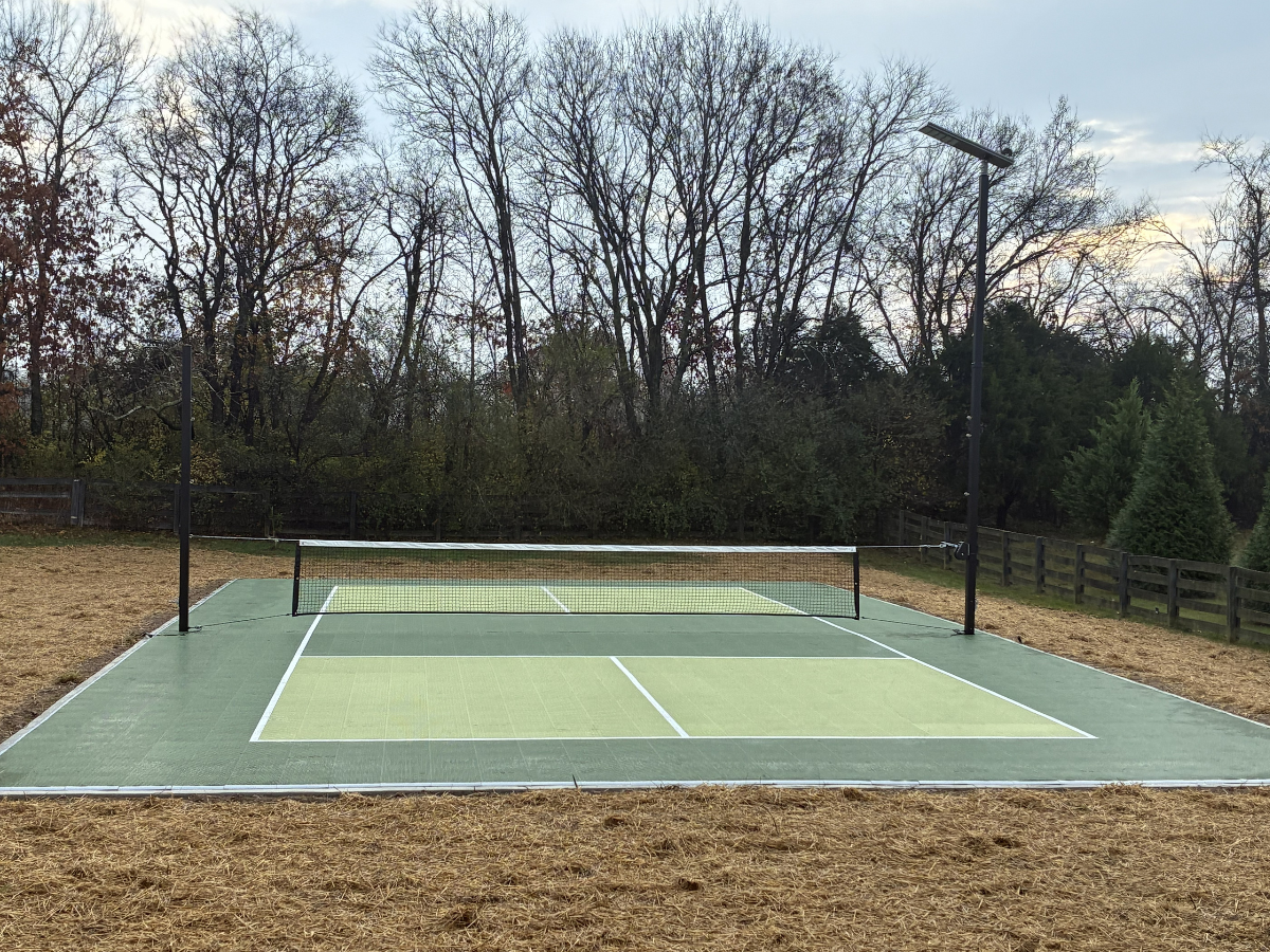 Outdoor pickleball court with solar lighting.