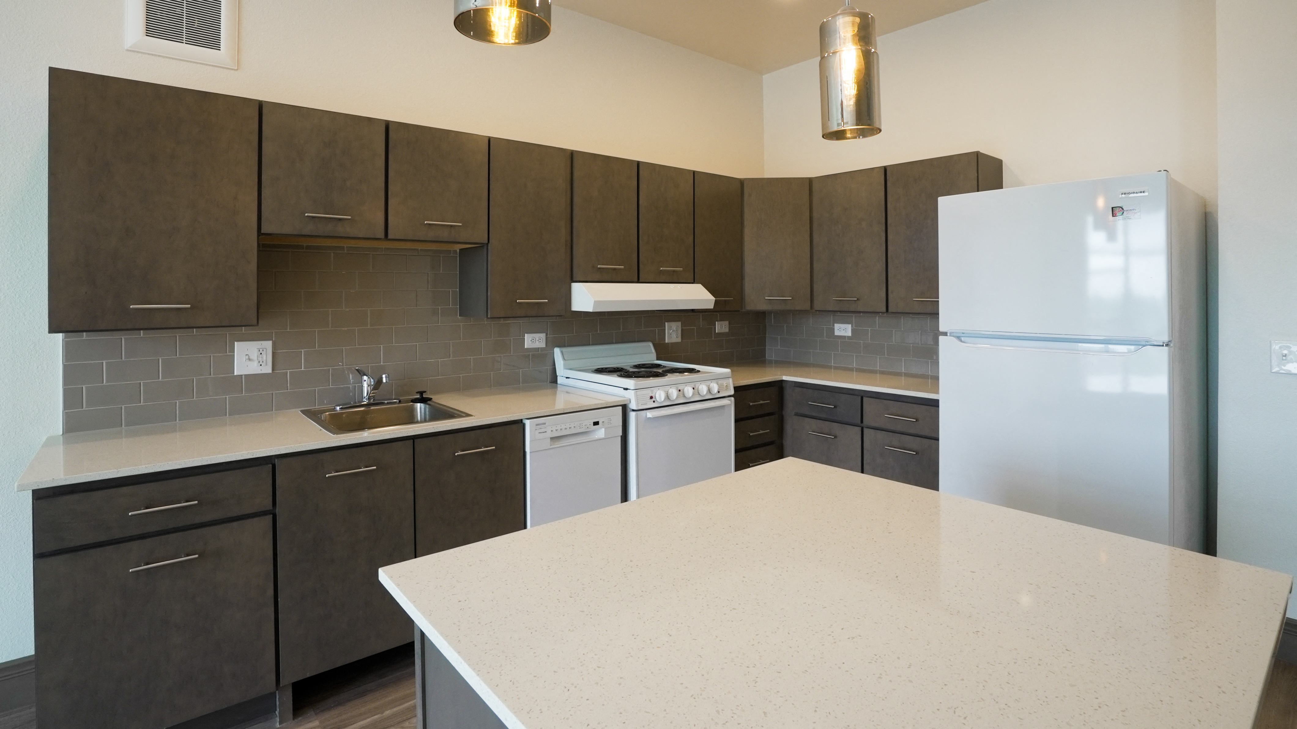 A kitchen with a white counter top and brown cabinets.