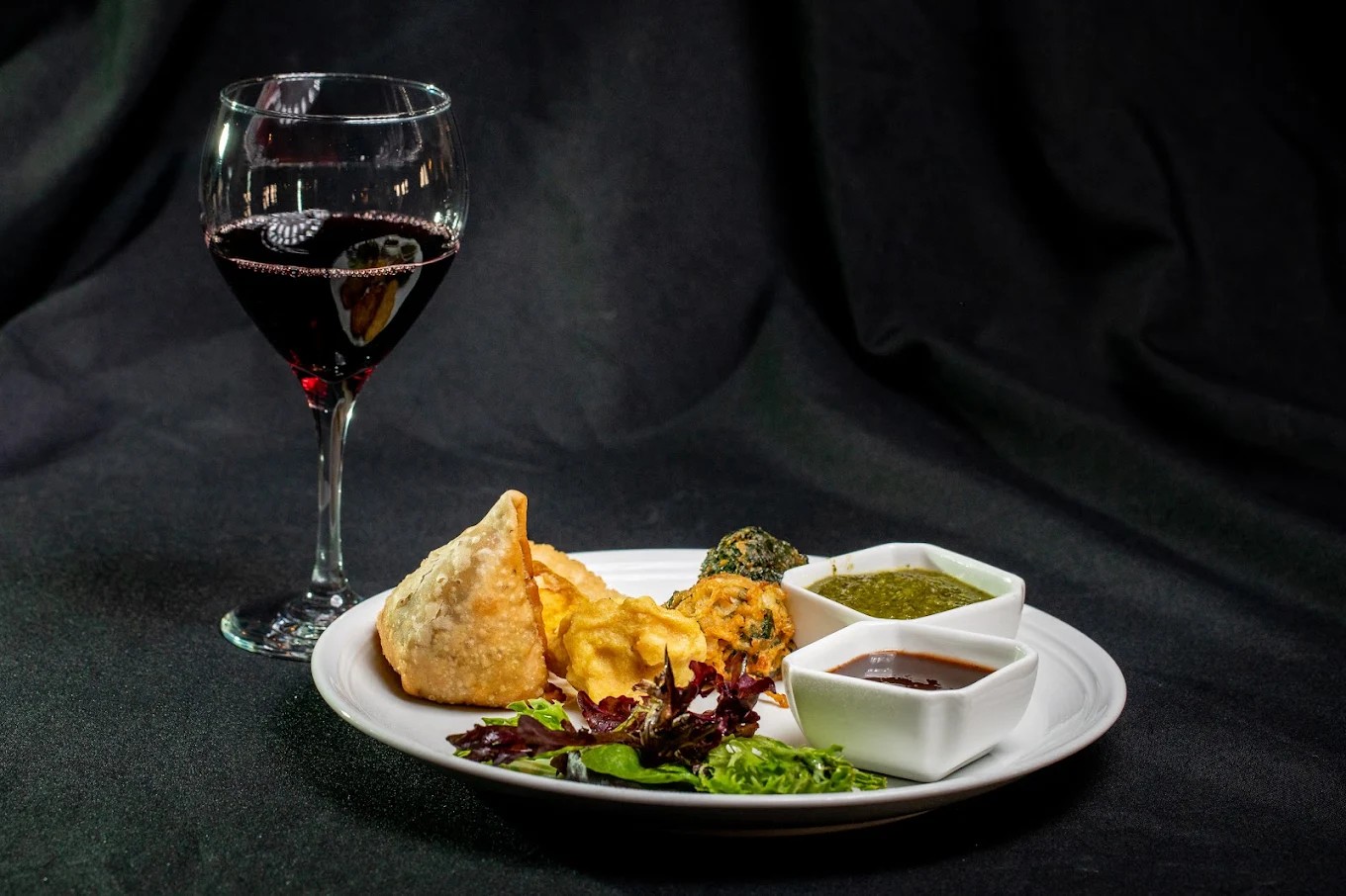 A refined appetizer selection featuring golden samosas, crispy pakoras, and house-made chutneys, pai 