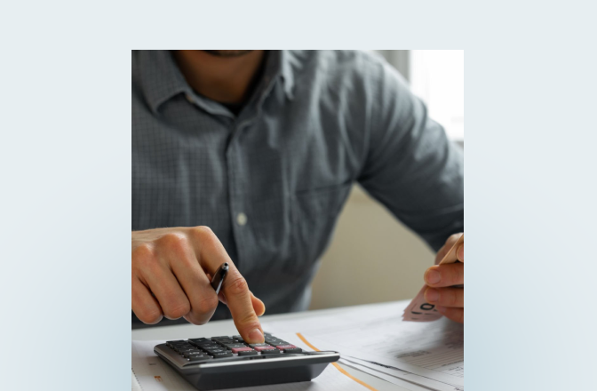 Close-up of a person using a calculator.