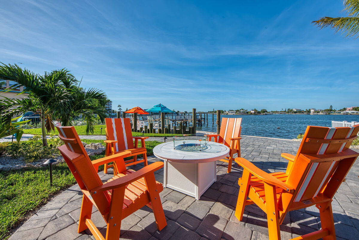 Outdoor waterfront lounge area with fire pit seating and intracoastal water views at FUSION Resort in Treasure Island, Florida.
