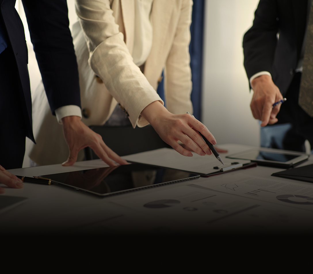 Close-up of professionals collaborating around a desk.