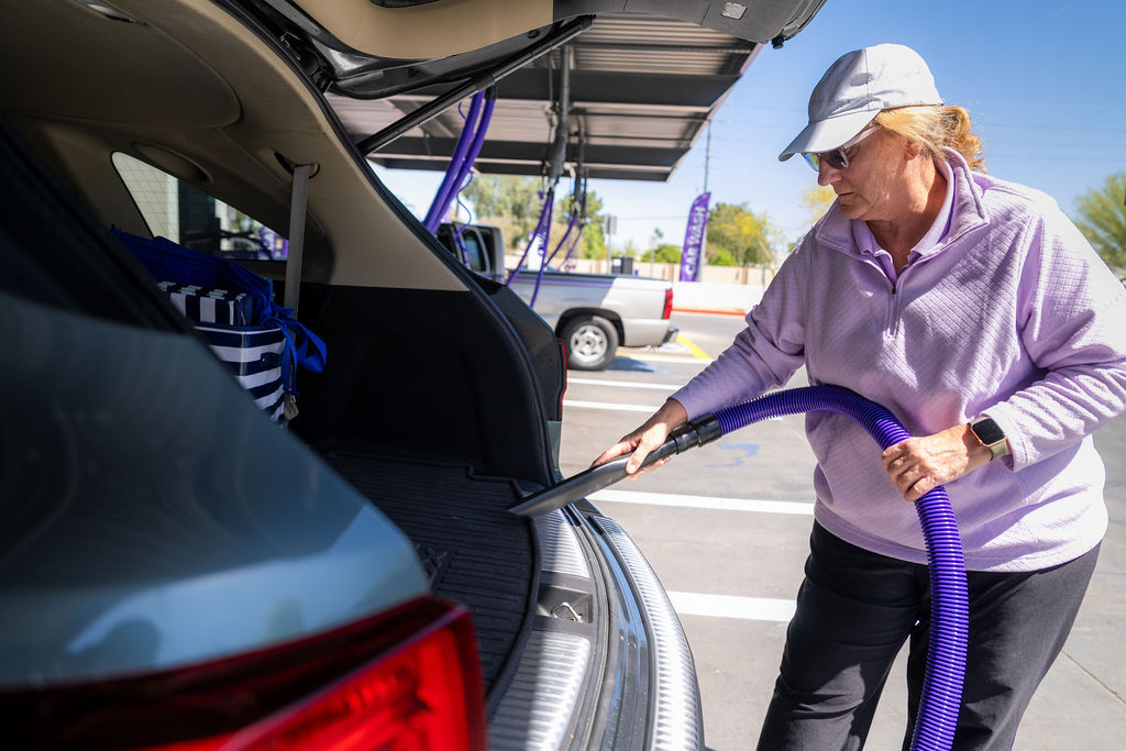 Customer using complimentary high-powered vacuum stations after a wash at DASH Car Wash Olive Ave. 