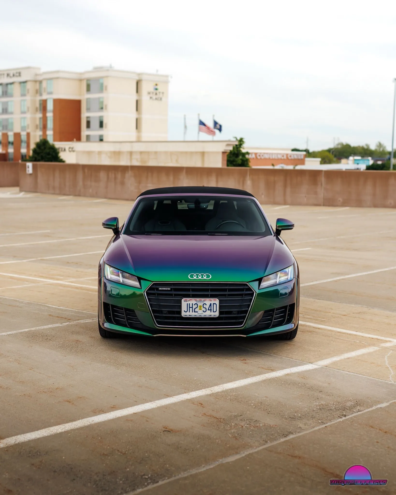 Front view of Audi TT convertible wrapped in striking color-shifting vinyl transitioning between green and purple hues, showcasing premium finish, modern styling, and professional automotive customization expertise.