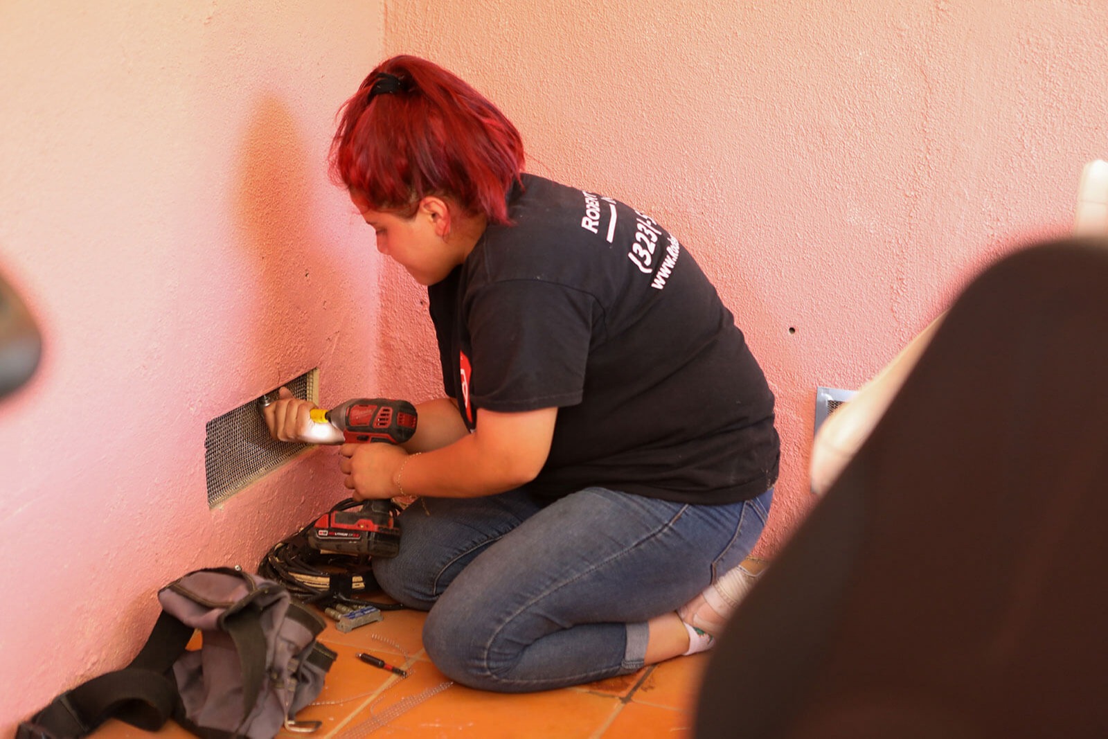 Rodent Control Inc. technician securing vent screening as part of rodent-proofing work.