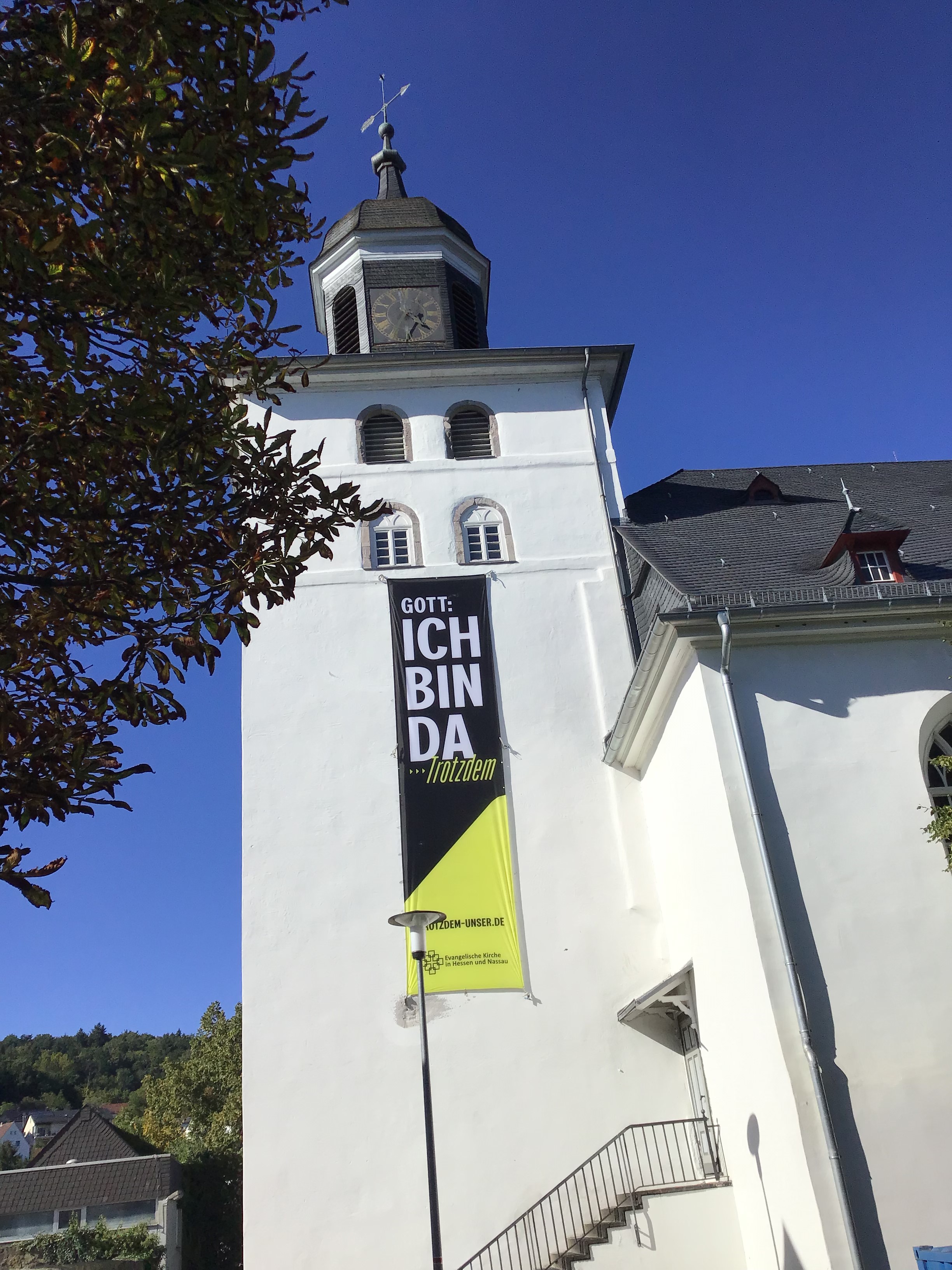 Die Stadtkirche der Evangelischen Kirchengemeinde Herborn mit Aktionsbanner der Impulspost zum Thema "Ich bin da - Trotzdem"