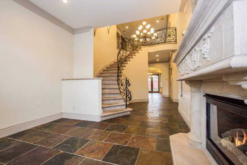 spacious living room with a magnificent spiral staircase, gorgeous tile flooring, and high ceilings in an Invitation Homes property in Northern CA