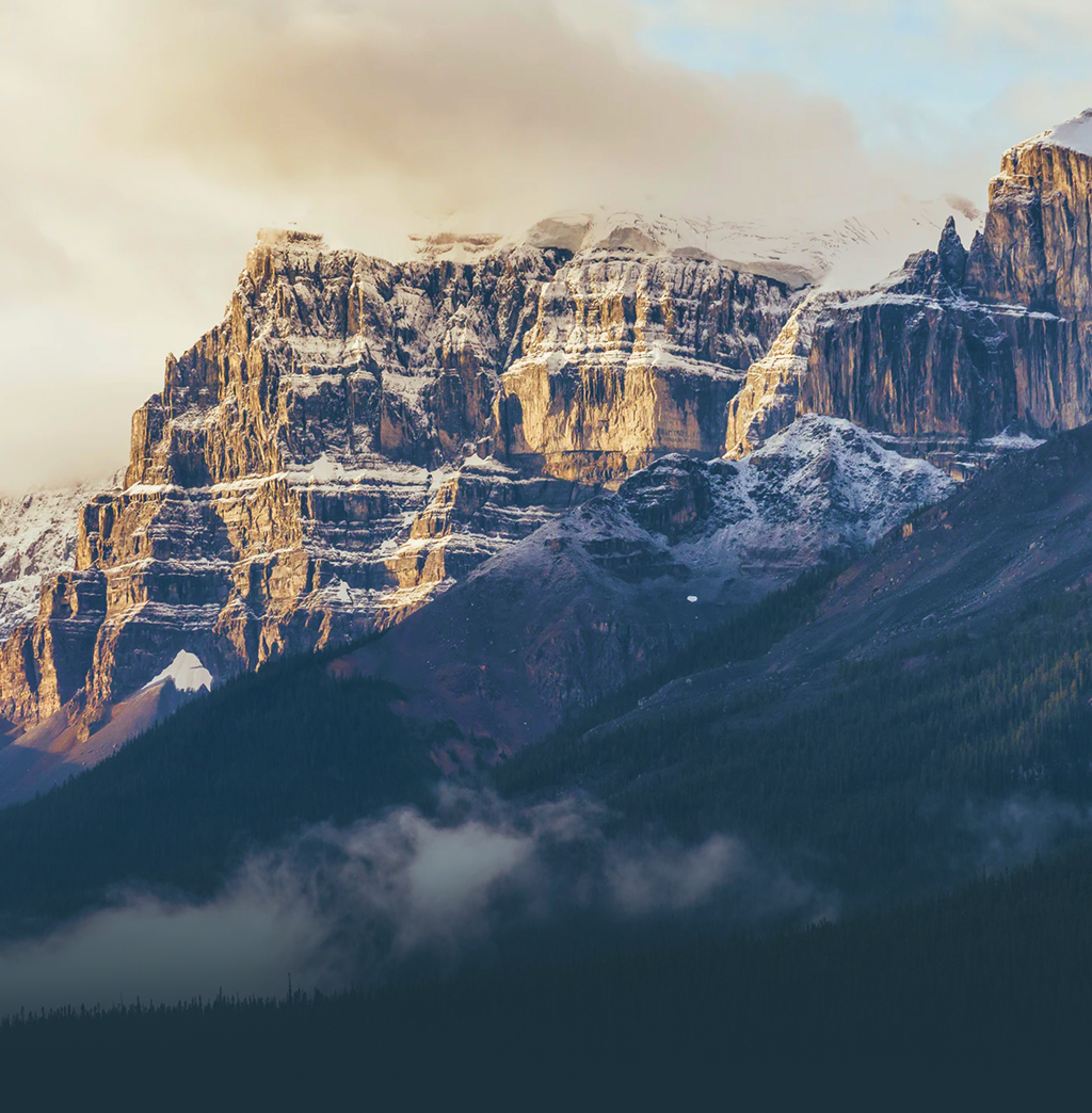 A scenic view of a mountain with mist in the valley.