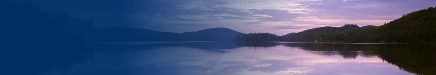 A calm lake reflecting a pink and purple sky.