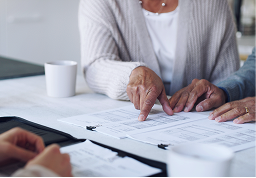 Close-up of clients meetings with their advisor to review documents.