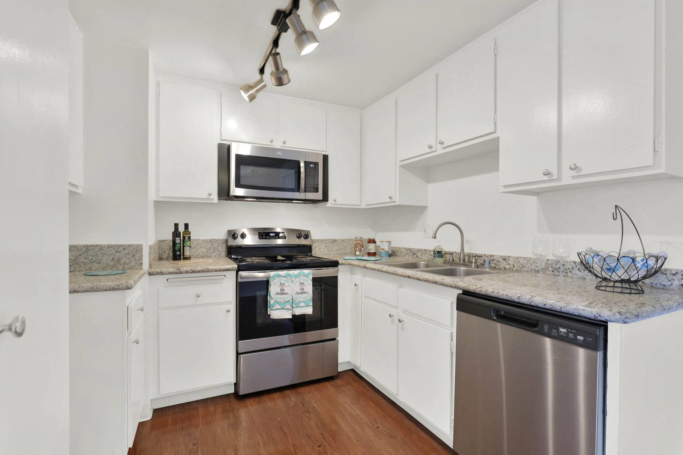 a kitchen with white cabinets and stainless steel appliances