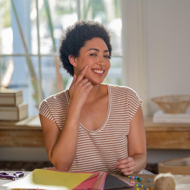 Ashley smiles, pointing at a heart-shaped birthmark on her cheek.
