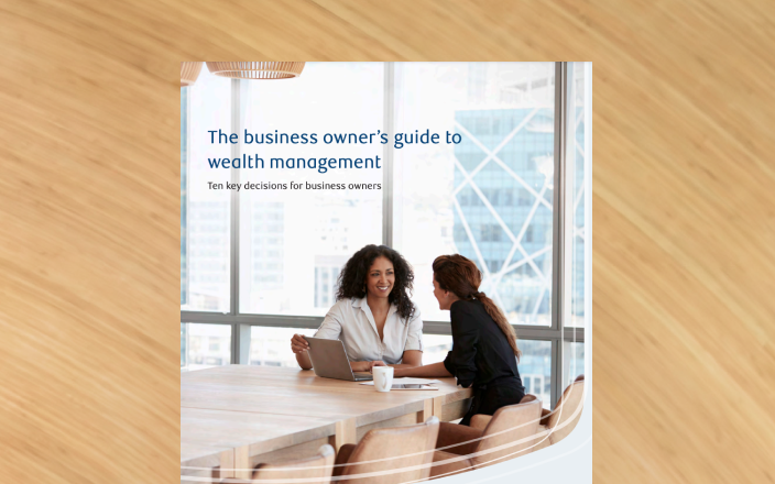 Cover of the business owner’s guide with two professionals at a board room table.