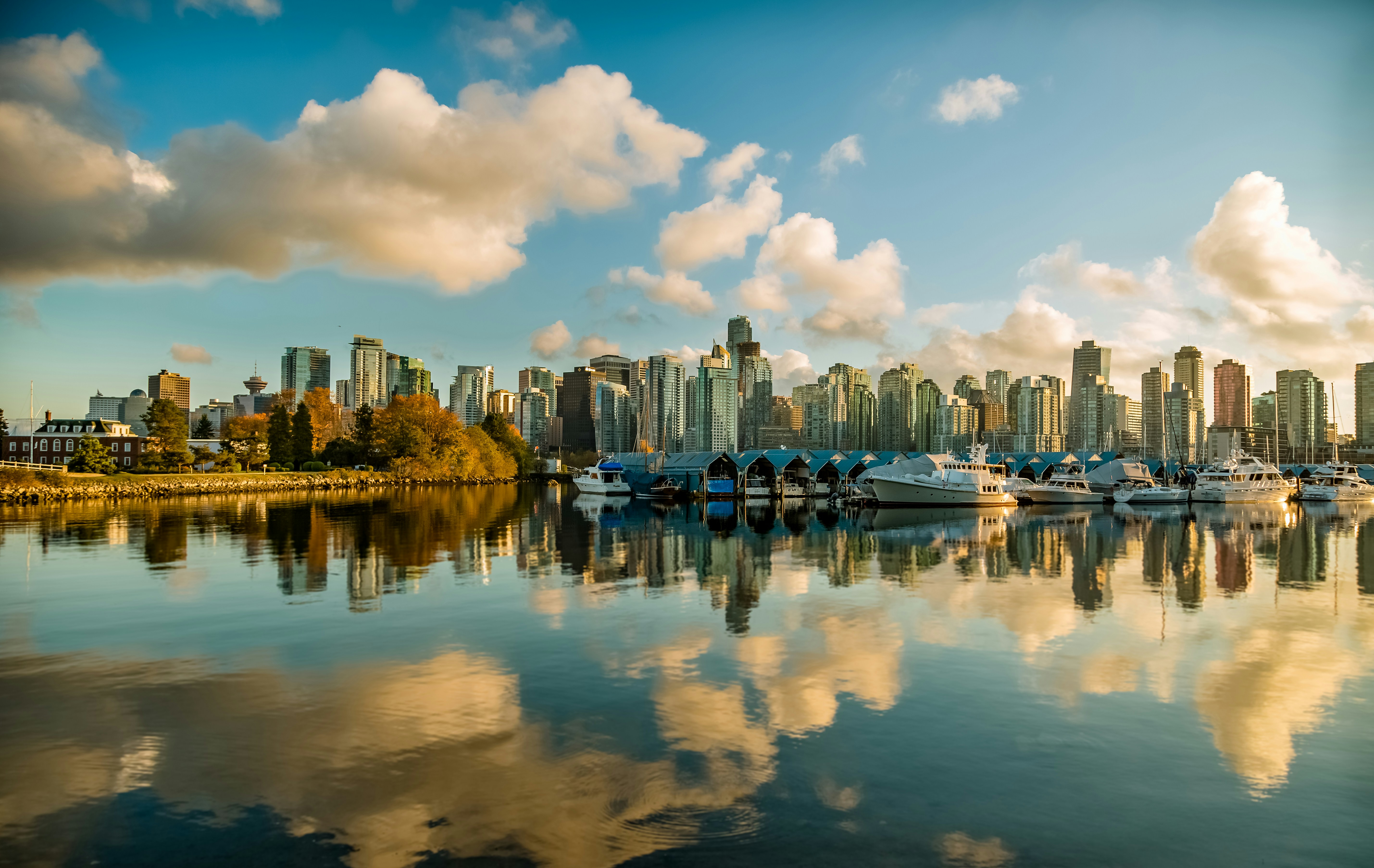 Vancouver skyline with marina and calm water reflections under blue sky
