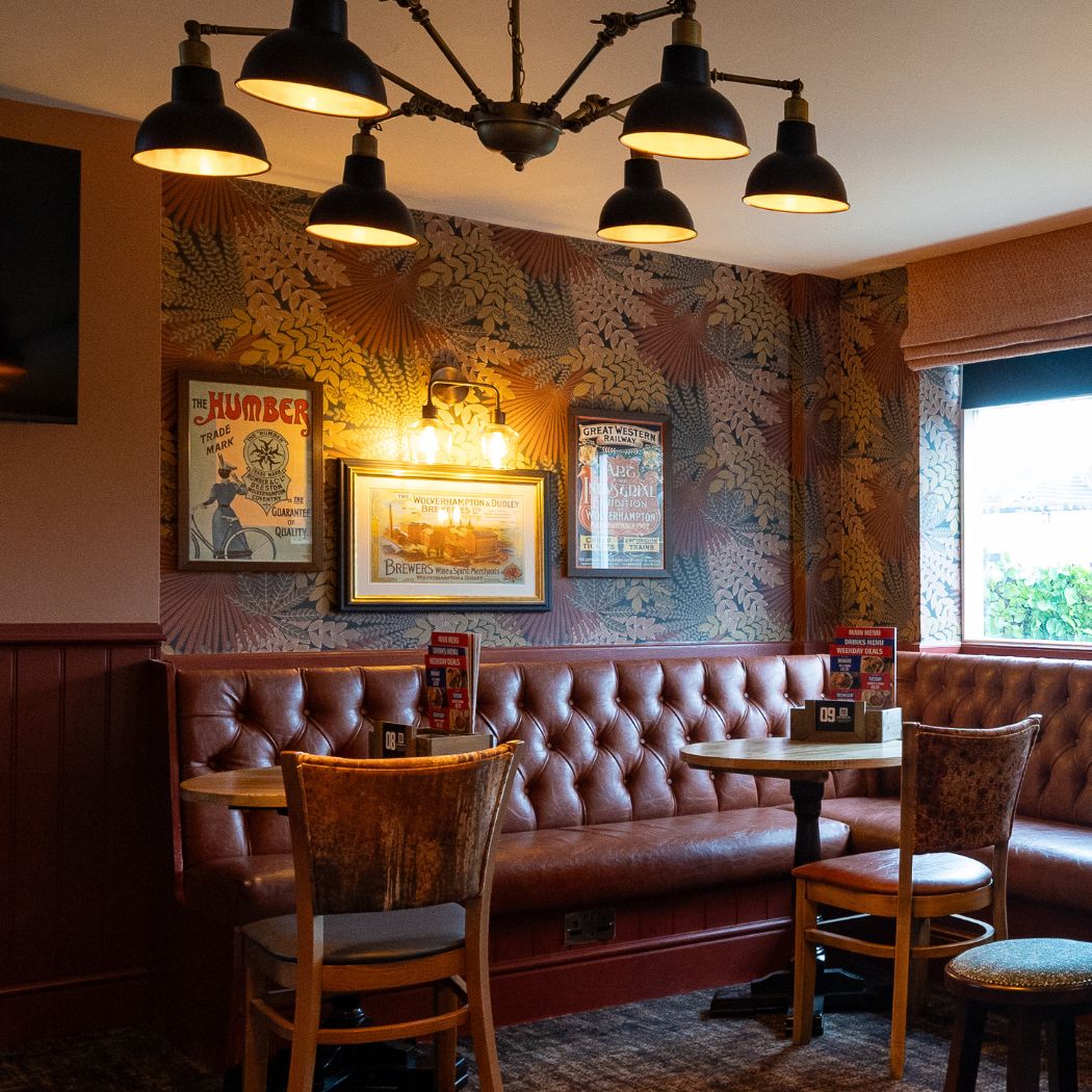 Cosy booth seating with classic pub decor and warm lighting, creating a welcoming space for drinks and casual dining.