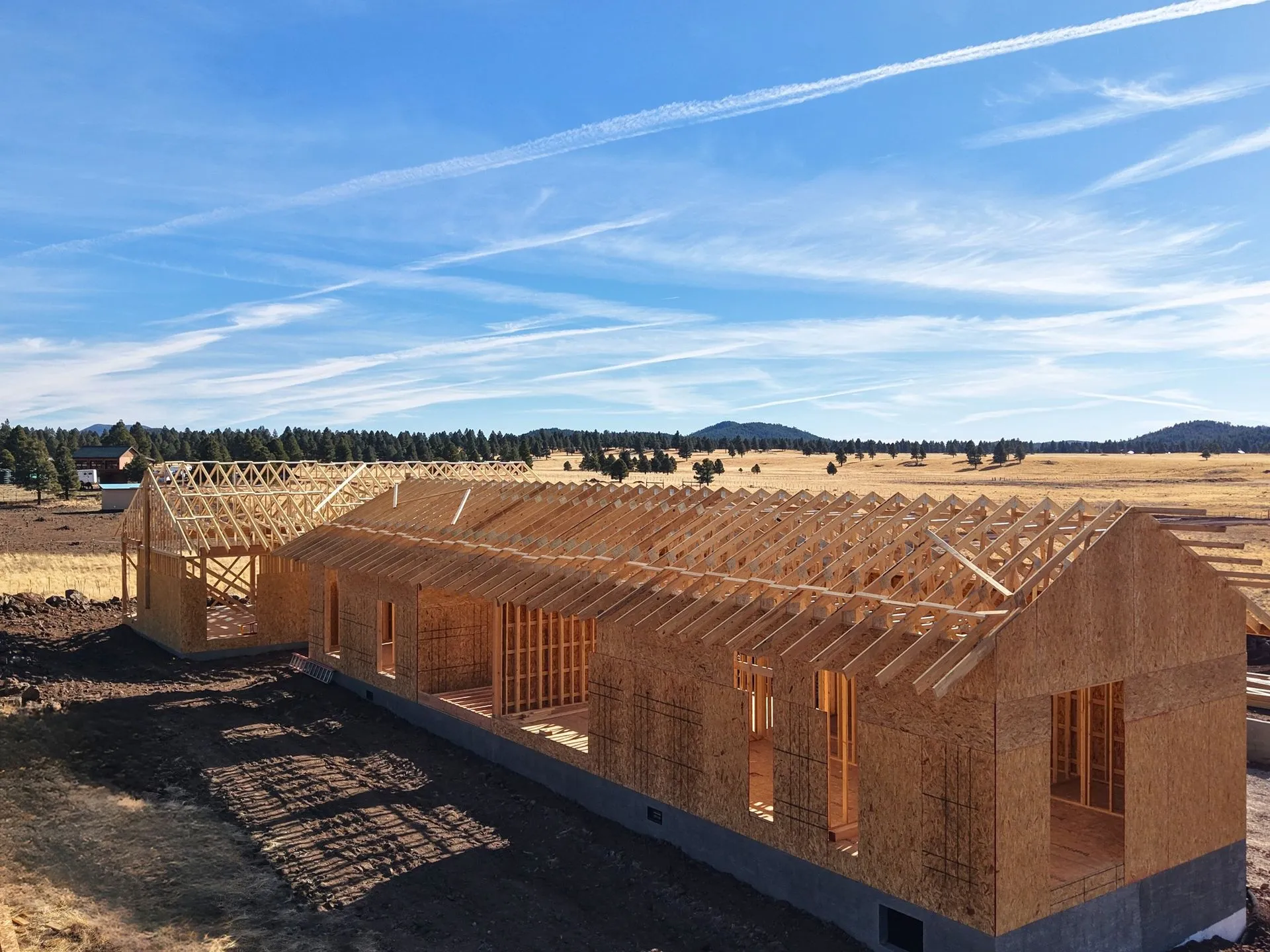 Residential construction project showing structural wood framing during the building phase. Precision craftsmanship and quality materials ensure a strong foundation for a custom-built home.