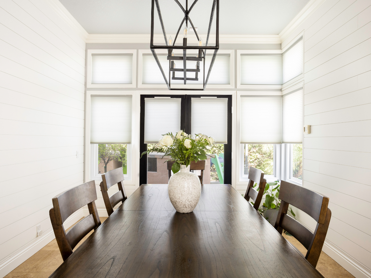 Cellular shades in a neutral dining room.