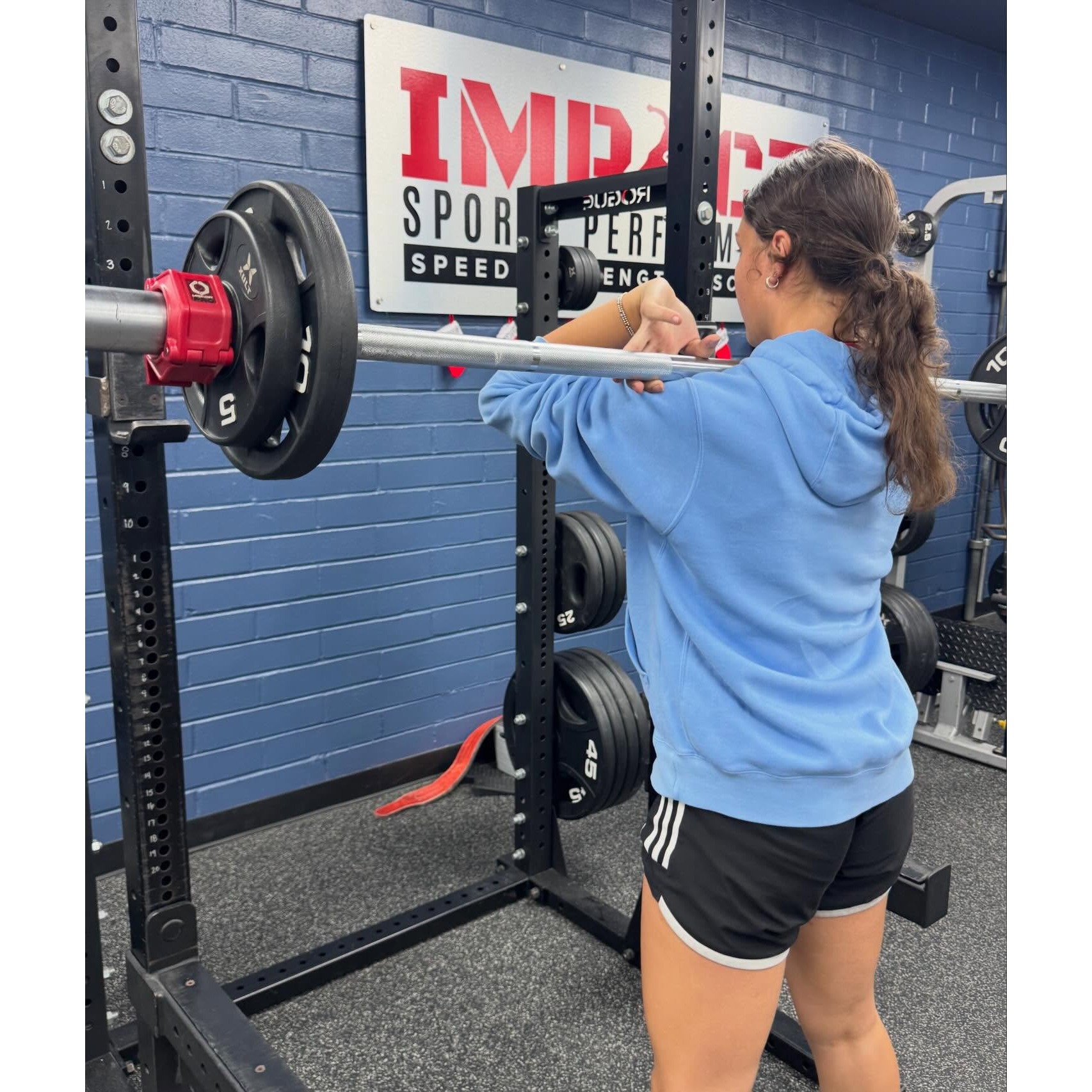 Middle school female athlete performing front squat at Impact Sports Performance