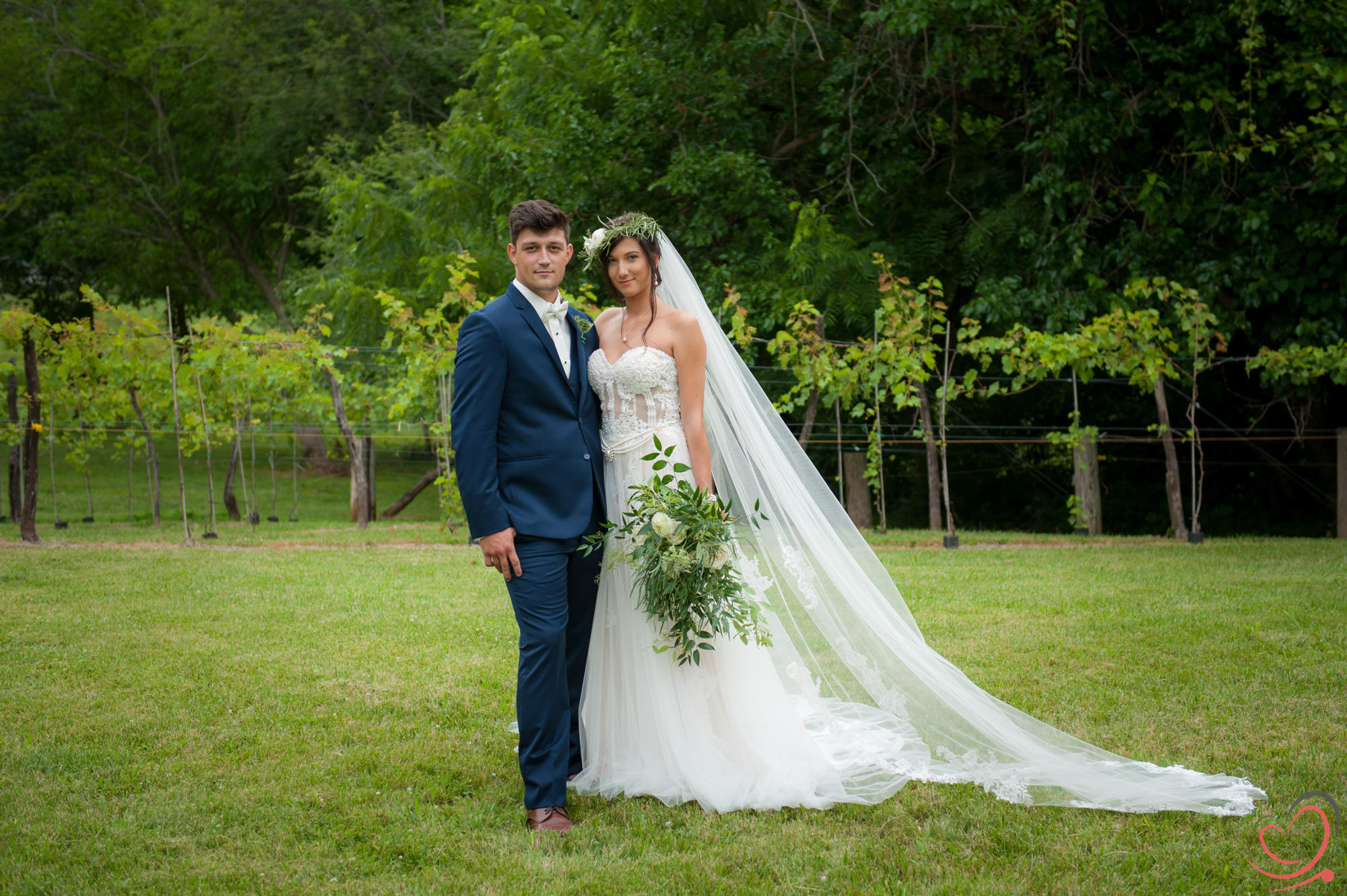 Beautiful bride and groom posing on the vineyard grounds.