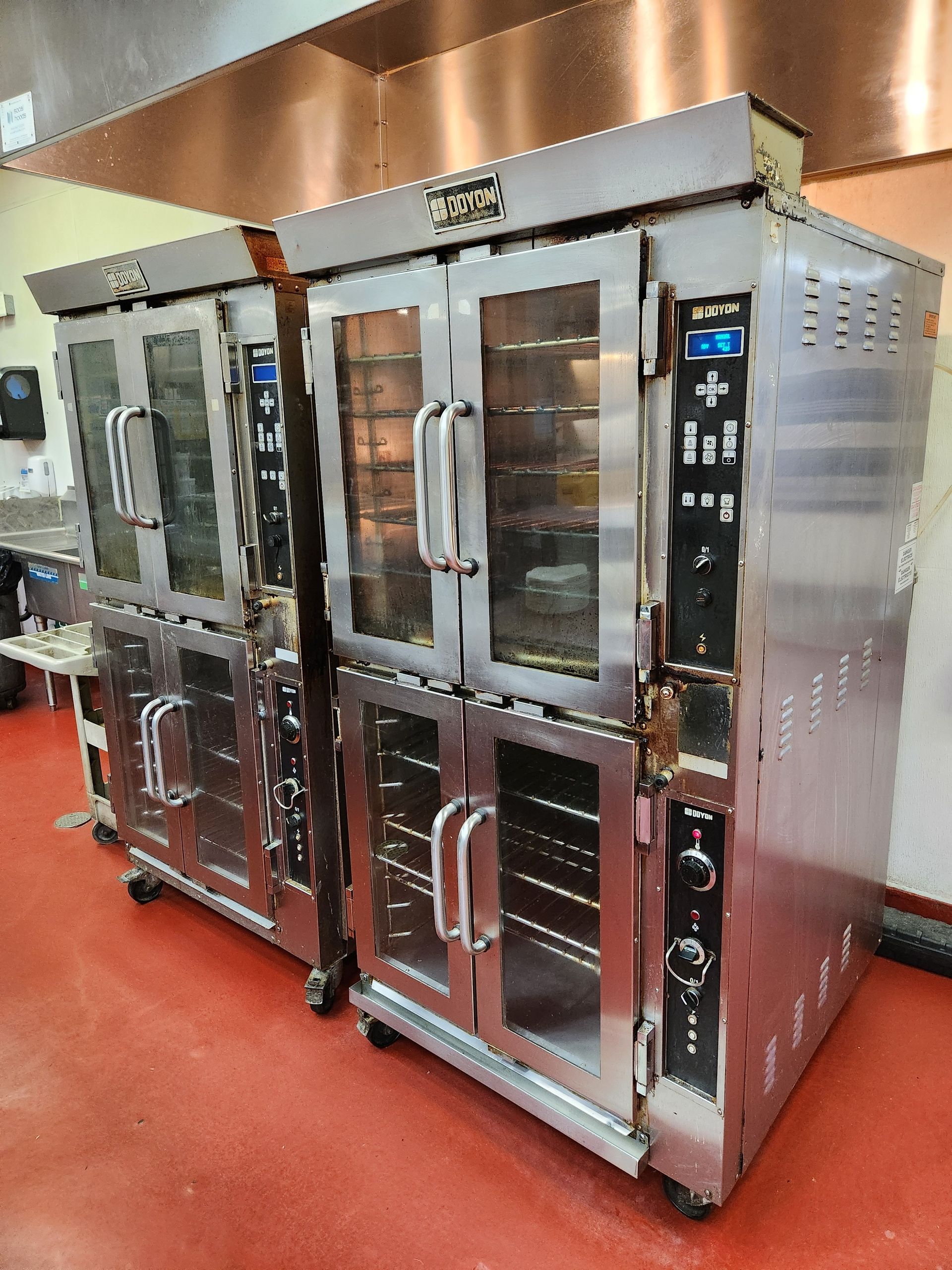 Commercial kitchen with multiple stainless steel Doyon ovens, glass doors, control panels, and venti 