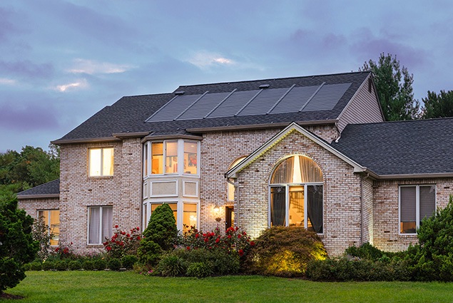 beautiful home at dusk with solar shingles installed by Renaissance Roofing