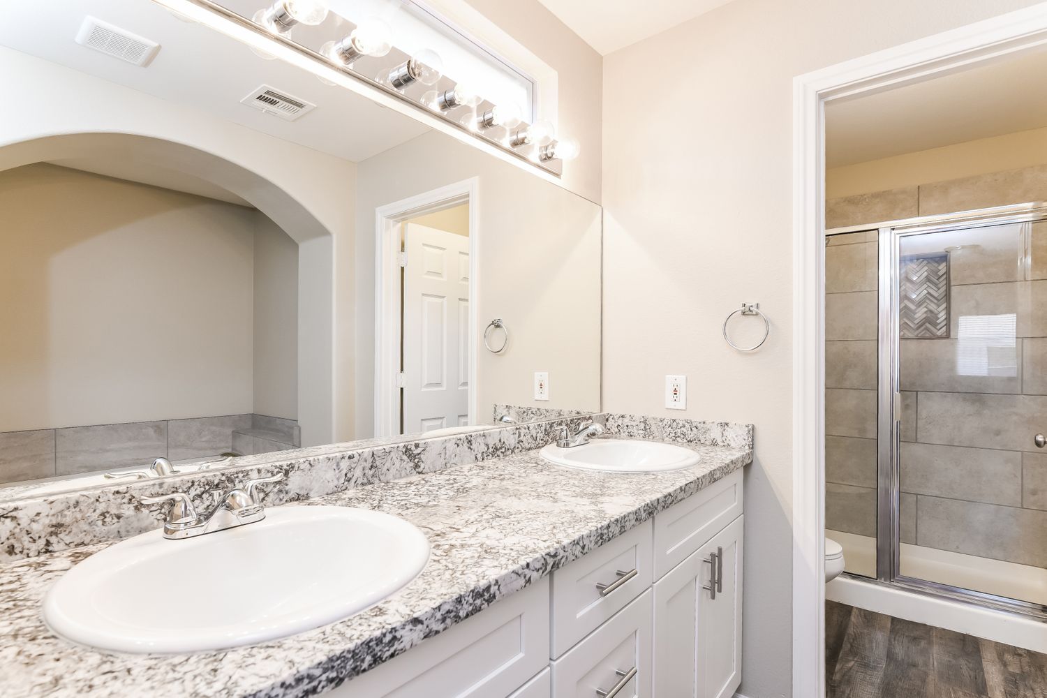 Upgraded bathroom with dual sinks and granite at Invitation Homes Las Vegas.