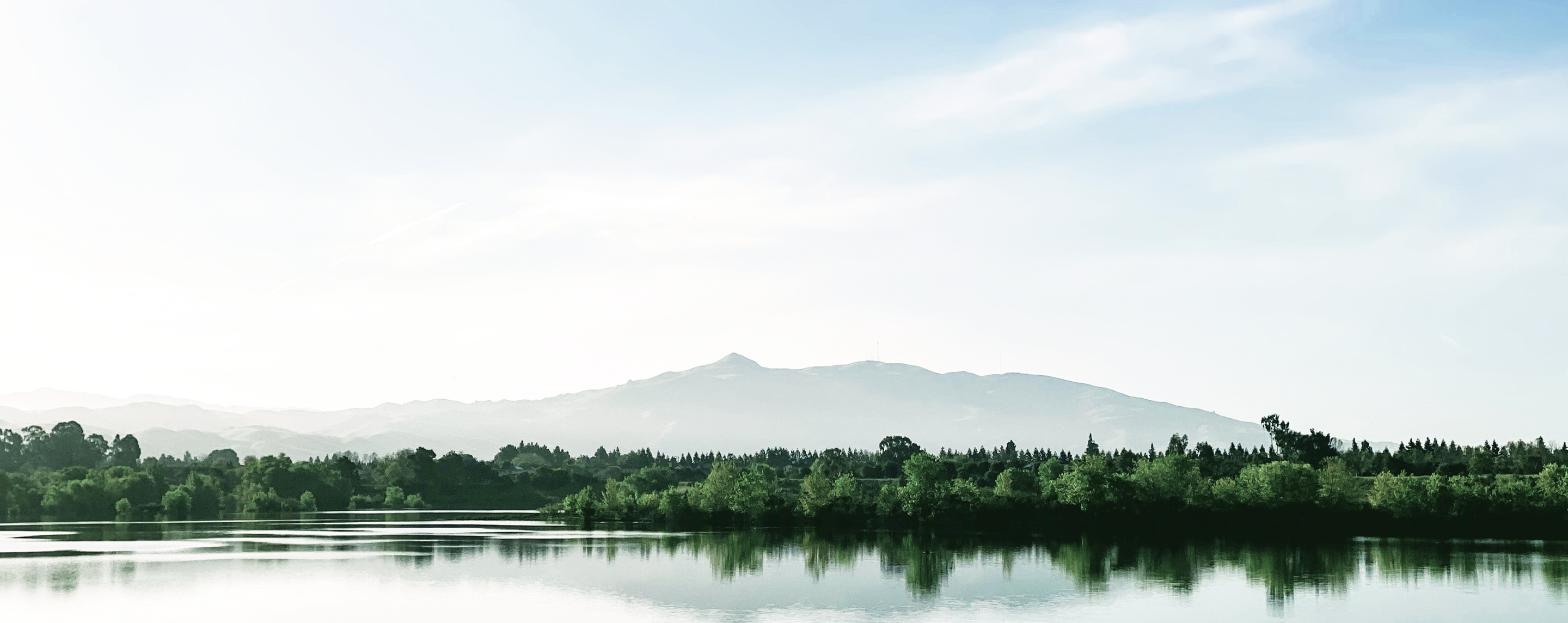 Beautiful landscape with calm water in the foreground and mountains in the background.