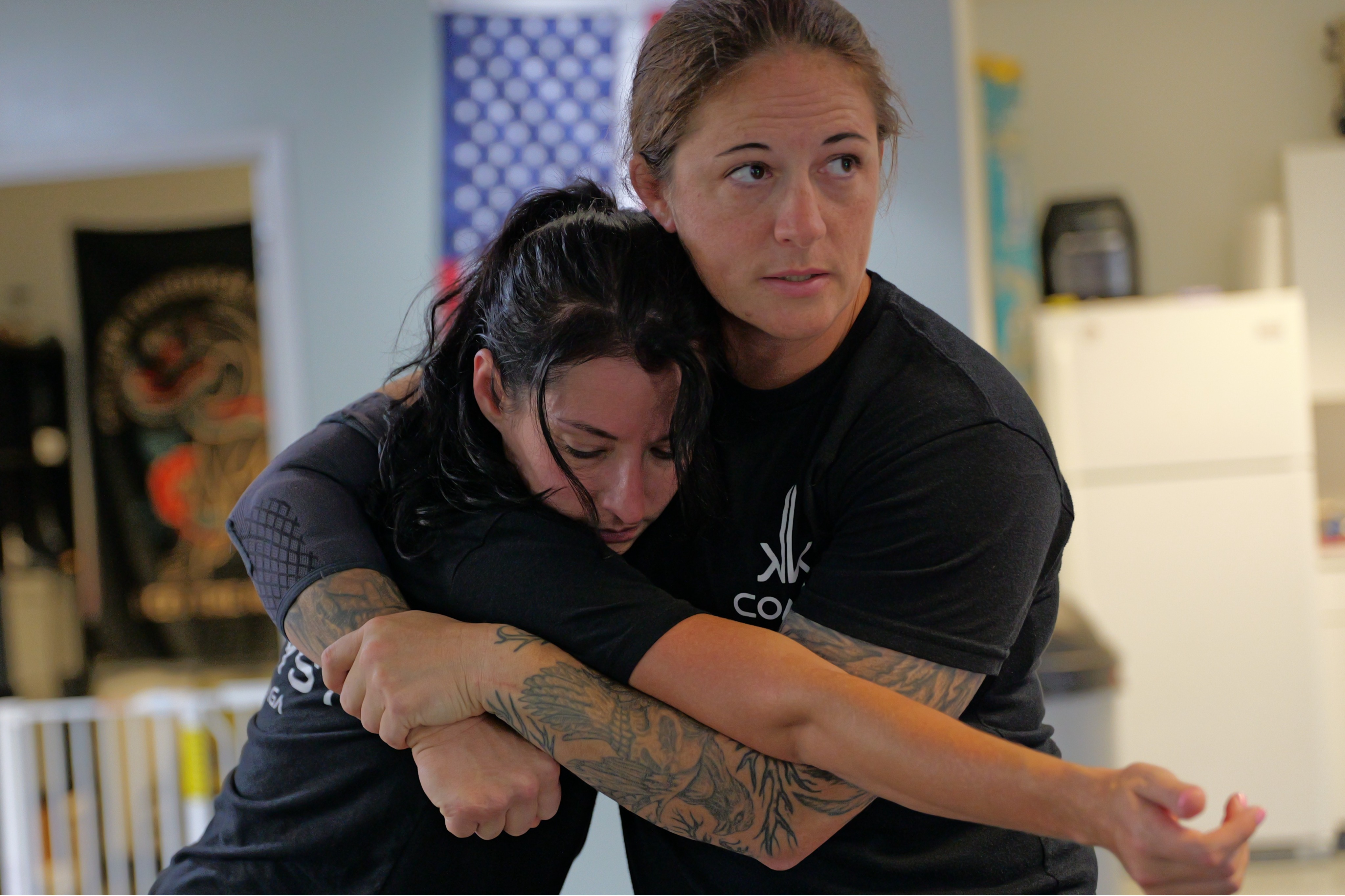 A student practicing an escape from a rear headlock during an adult self-defense class.