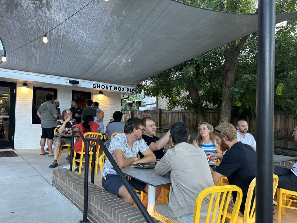 Guests enjoy Detroit-style pizza, drinks, and outdoor dining on the patio at Ghost Box Pizza in Lafayette.