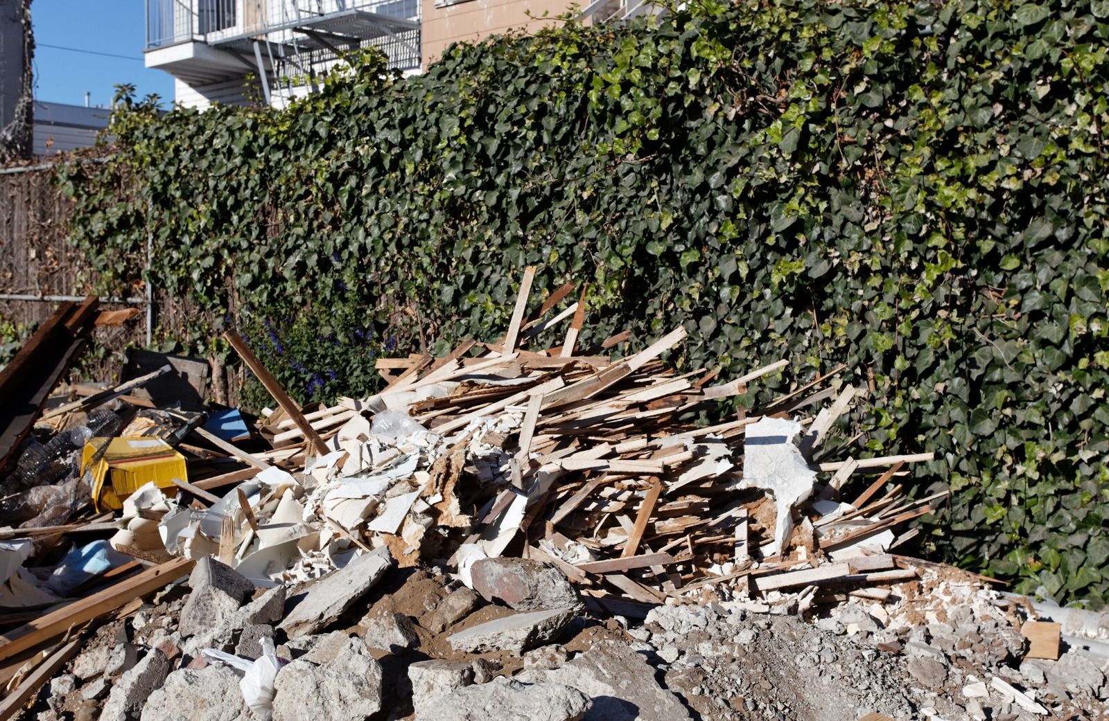 Pile of construction debris including wood, drywall, and rubble, illustrating cleanup after demolition or renovation, emphasizing waste removal and site clearing services.