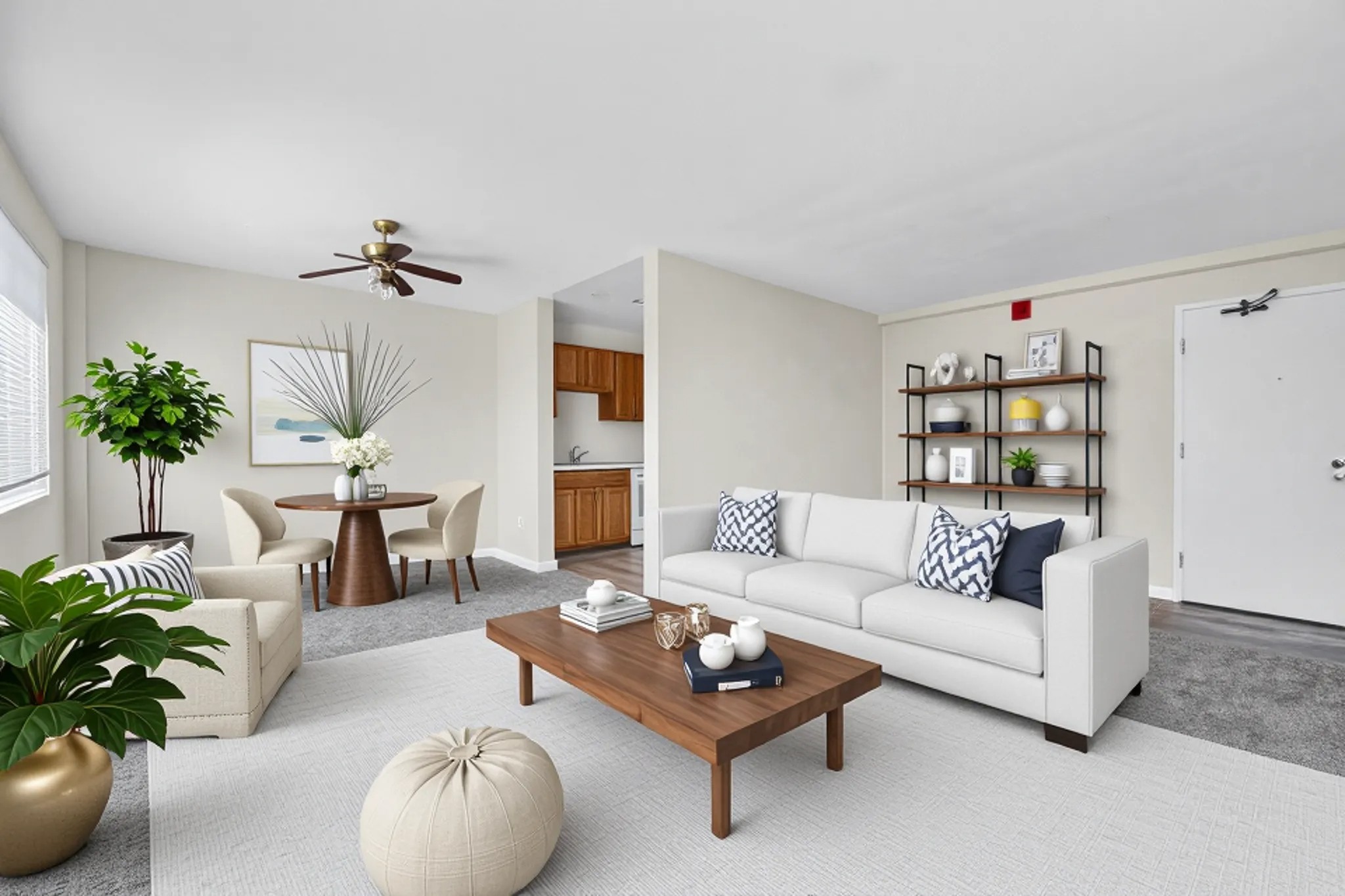 A living room with a white couch, a coffee table, and a ceiling fan.