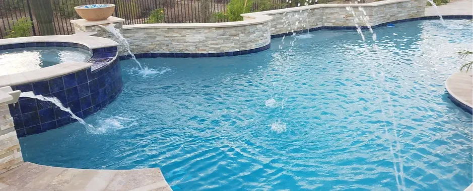 This breathtaking Scottsdale pool features custom tilework that adds a touch of elegance, complemented by decorative stone walls that create a stunning backdrop. Cascading water features and spillways enhance the ambiance, bringing both movement and tranquility to this luxurious backyard retreat.