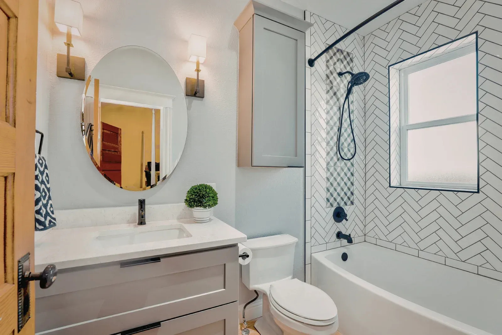 Contemporary bathroom remodel showcasing elegant fixtures, custom vanity, decorative tilework, and bright finishes. The upgraded space offers improved functionality, comfort, and visual appeal for homeowners.