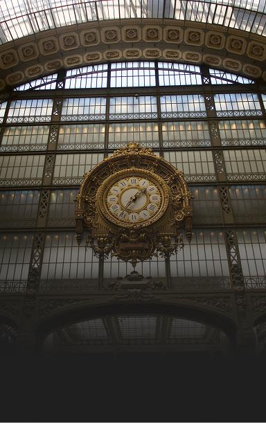 Bottom-up view of a large, ornate clock on the side of a window-lined wall in a historic building.