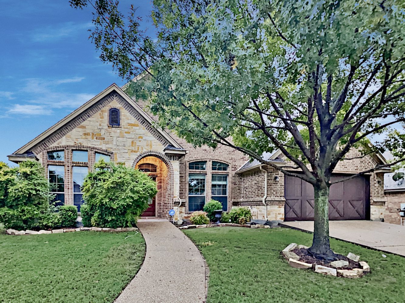 Charming home with a long walkway and two-car garage at Invitation Homes Houston.