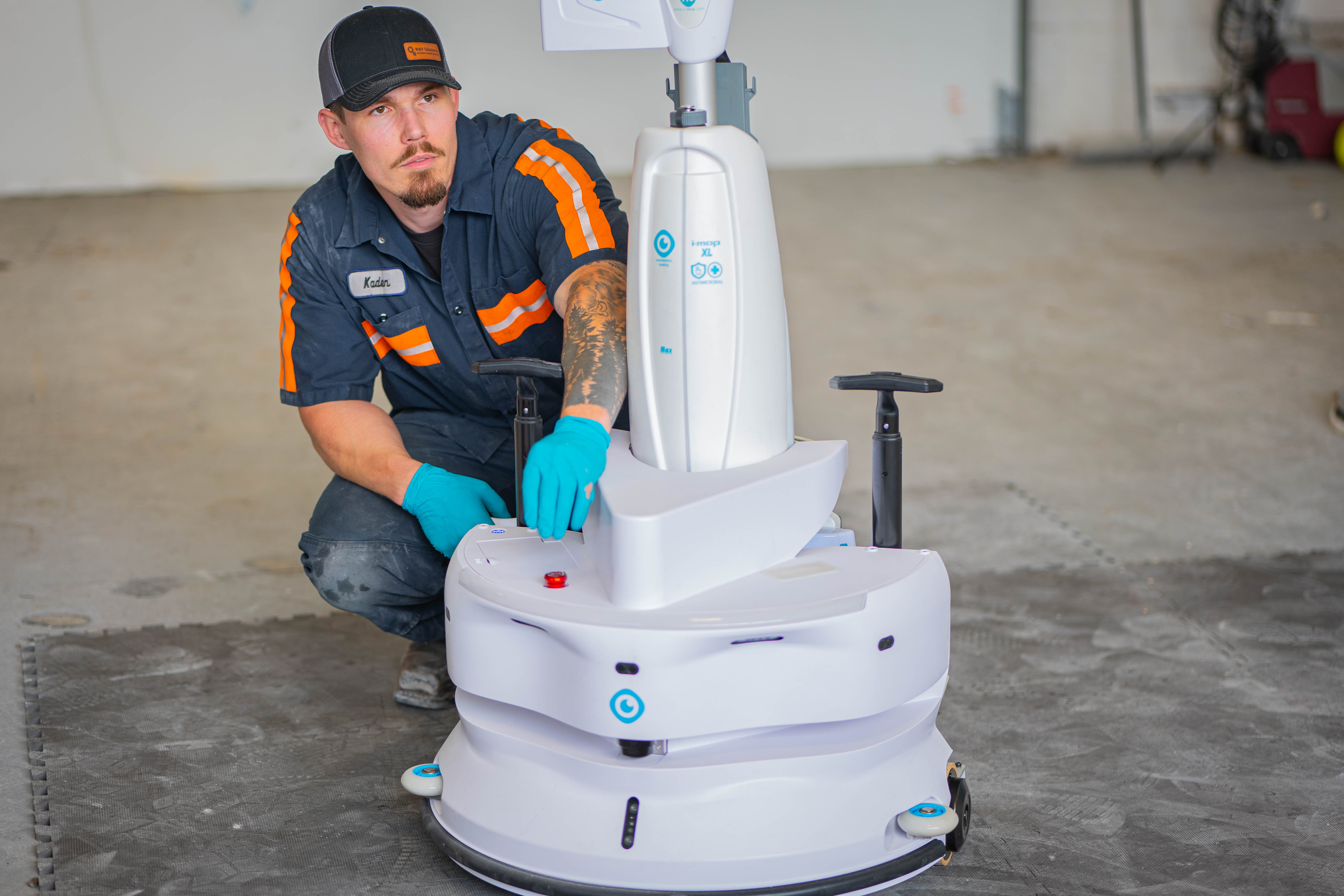 Equipment Model: i-mop XL Professional Scrubber with autonomous robotic base
Action: Systems check and user-interface calibration on the robotic chassis
Personnel: Lead technician Kaden wearing protective nitrile gloves
Service Focus: Advanced robotic cleaning equipment maintenance and high-tech diagnostics