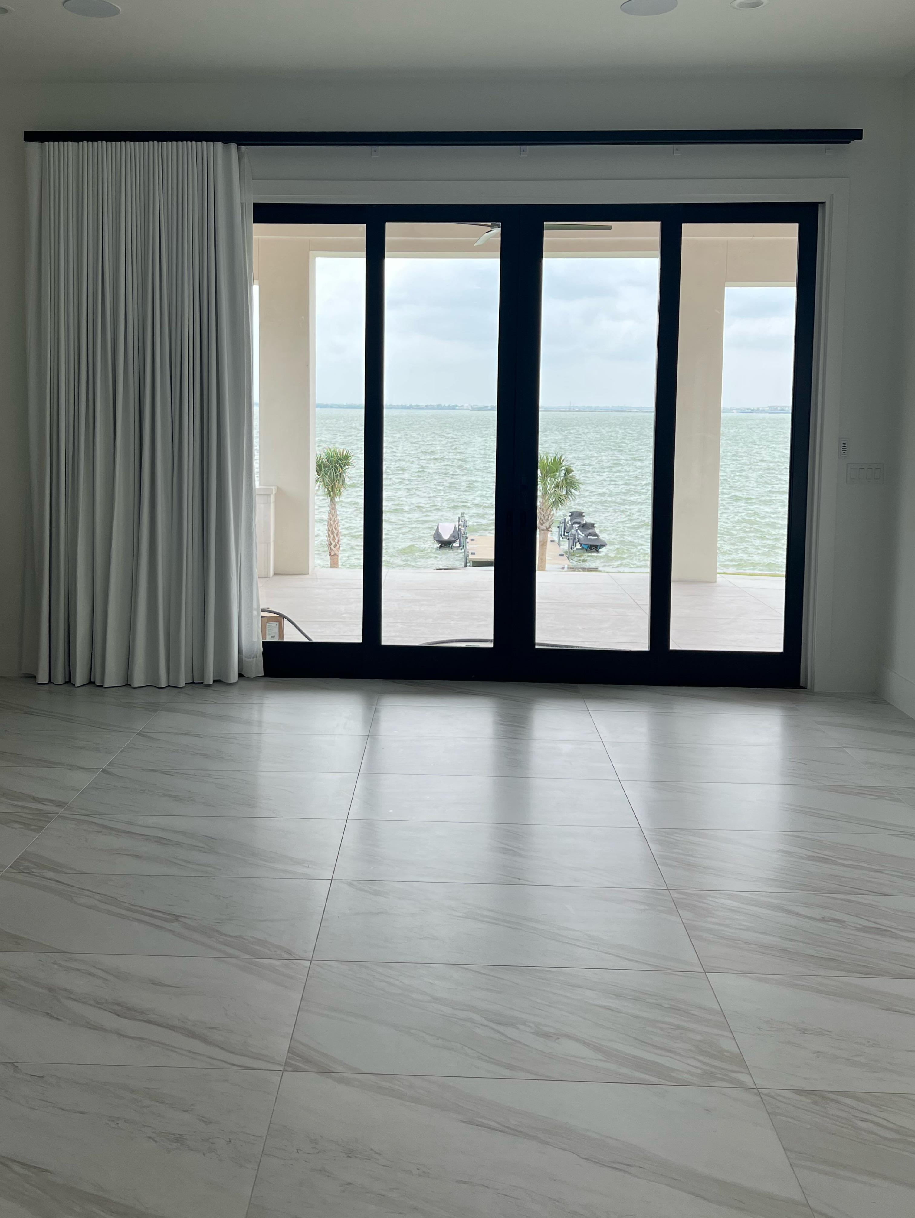 White drapery is classic style for covering patio doors and windows. The Budget Blinds of Rockwall, Terrell, and Greenville design team love the classic look of pinch pleat drapery or curtains.