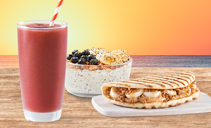 Tropical Smoothie Cafe lunch meal featuring a Detox Island Green® Smoothie, Acai bowl/smoothie bowl with Nutella® and fresh fruit, Caribbean Jerk Chicken Wrap sandwich, Kale & Apple Slaw side – perfect for a healthy or GLP-1 friendly option.