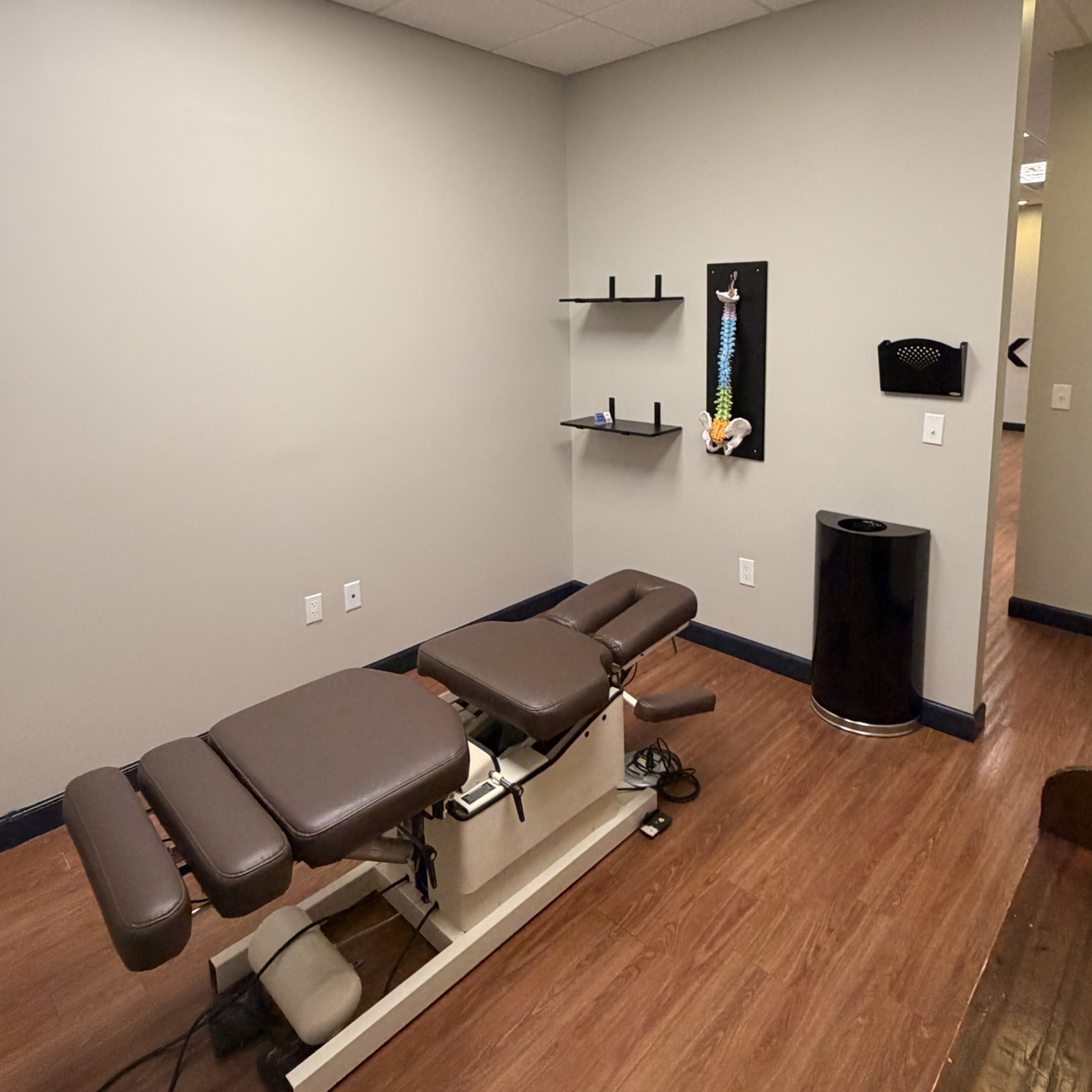 One of our private adjustment rooms, with a professional adjusting table and a spine model we use to 