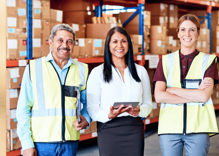 Three people standing in a warehouse.