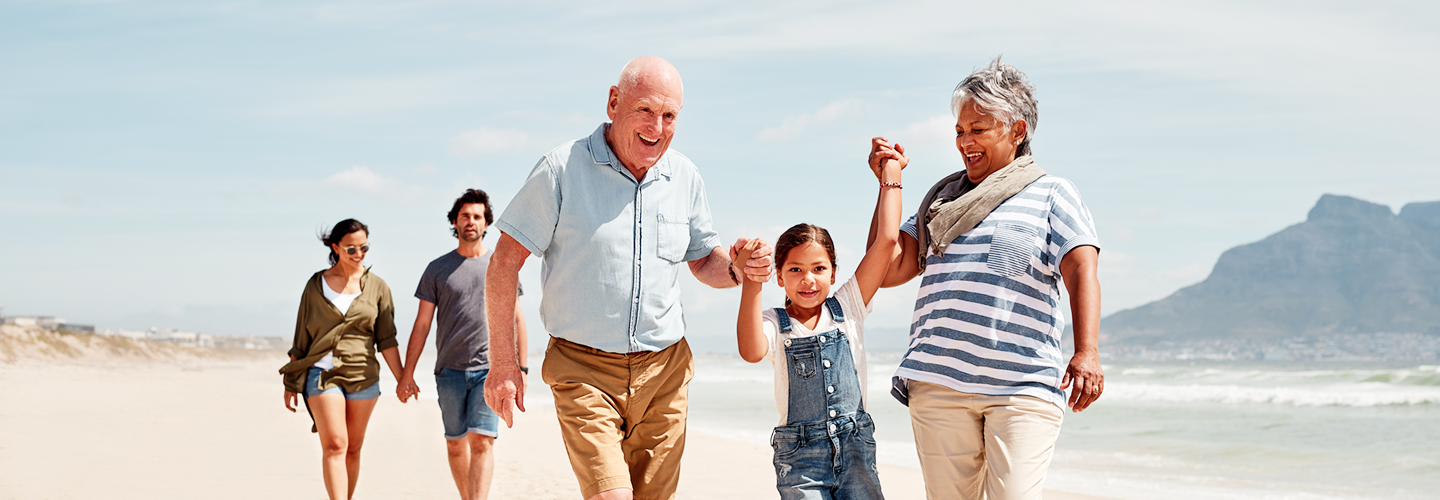 A multigenerational family walking on the beach.