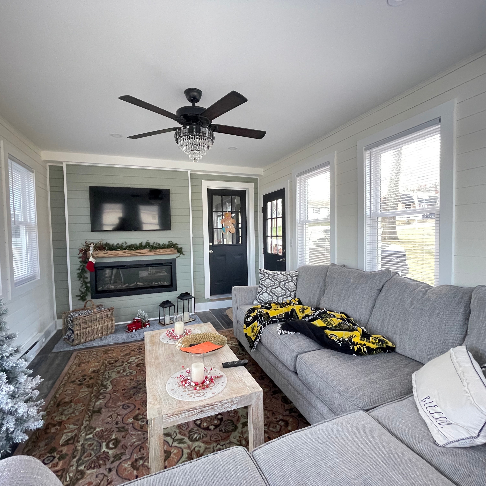 Cozy and stylish living room featuring a fireplace, sectional sofa, and large windows for natural light. Designed for relaxation and entertainment in a warm, inviting space.