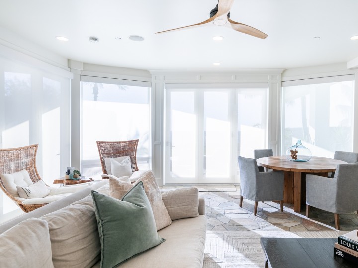 Layered textures and soft, flowing drapery with a structured Roman shade create a cozy yet refined look in this space.