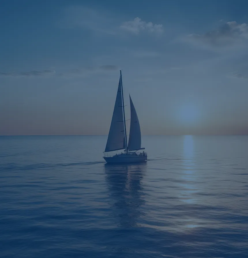 A sailboat gliding across calm open water toward a golden sunset on the horizon.