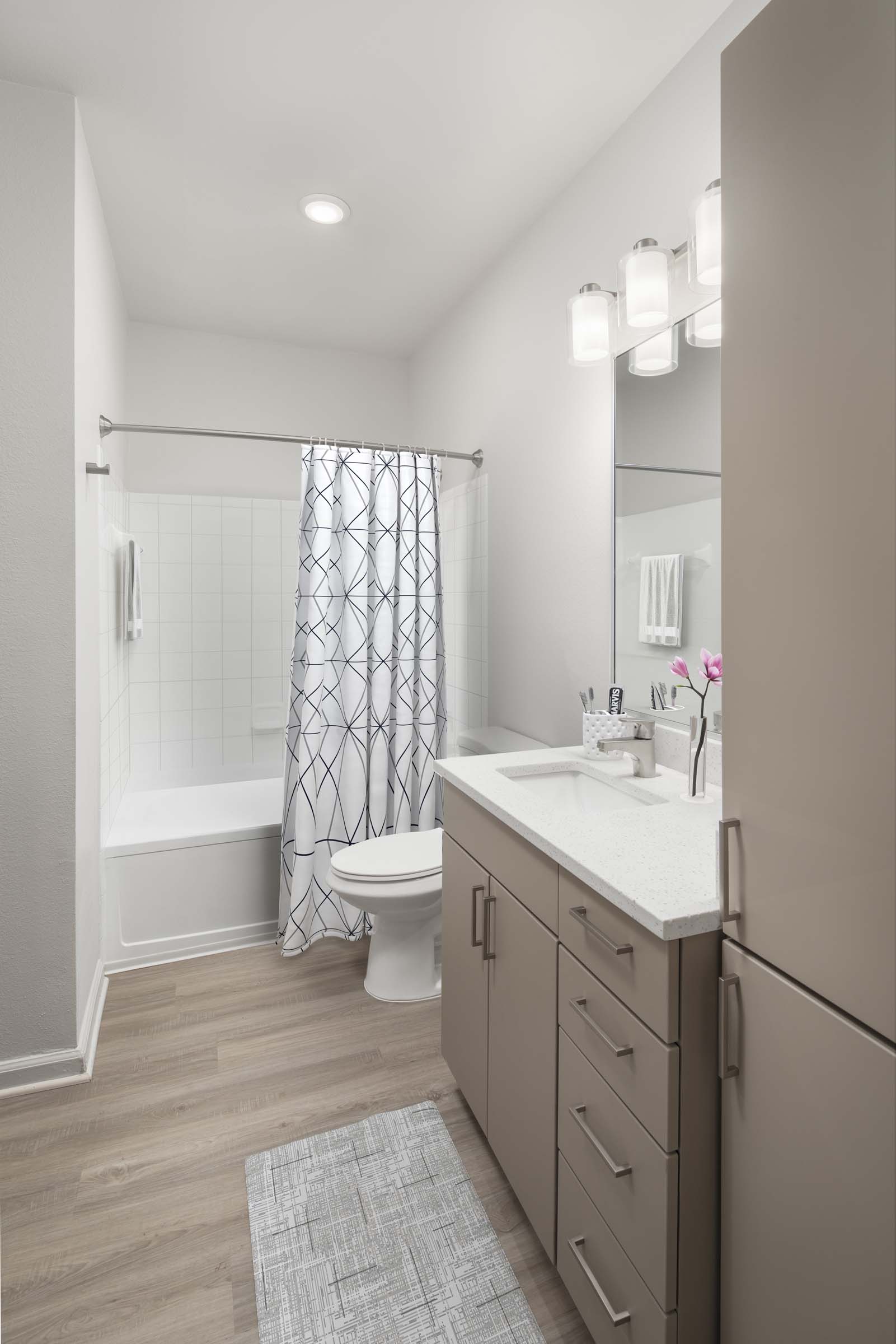 Contemporary finish style features mocha matte cabinets and white quartz countertops and large soaking bathtub.