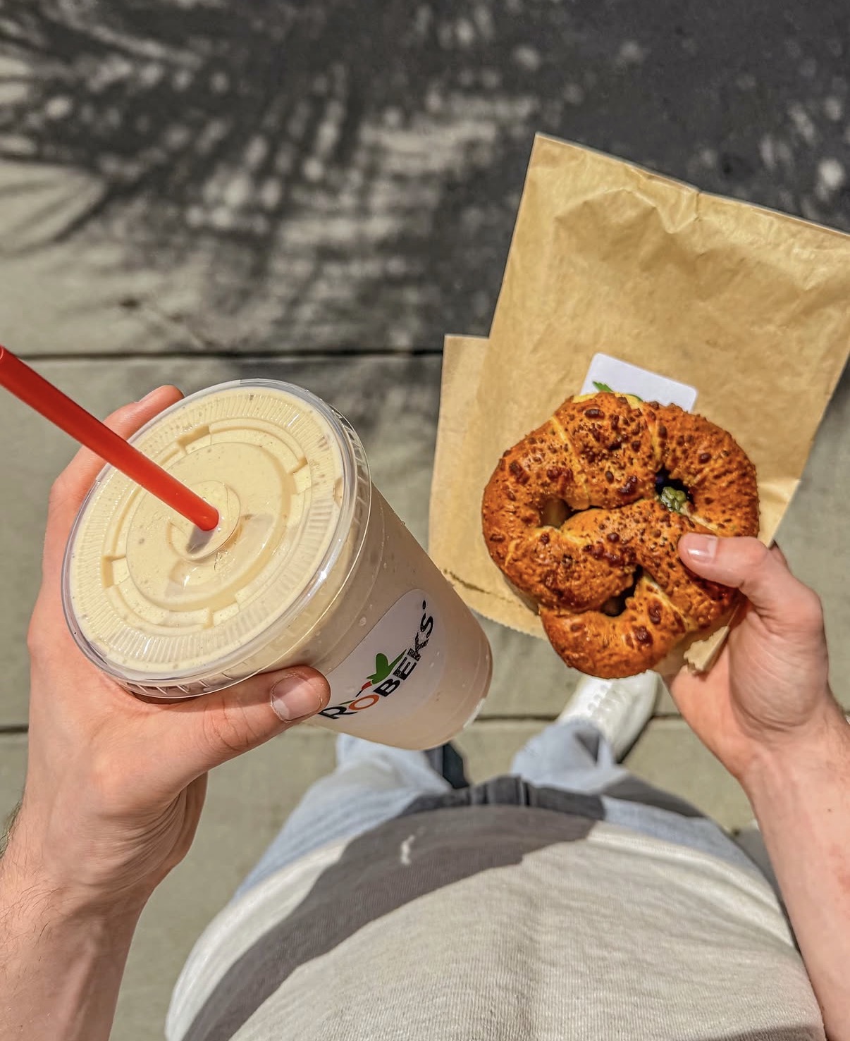 Enjoying the sun with a smoothie and spinach pretzel in hand.