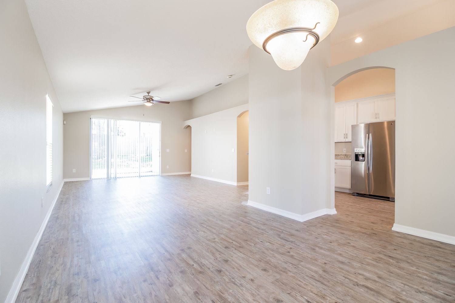 Spacious living room and dining area with easy kitchen access at Invitation Homes Orlando.