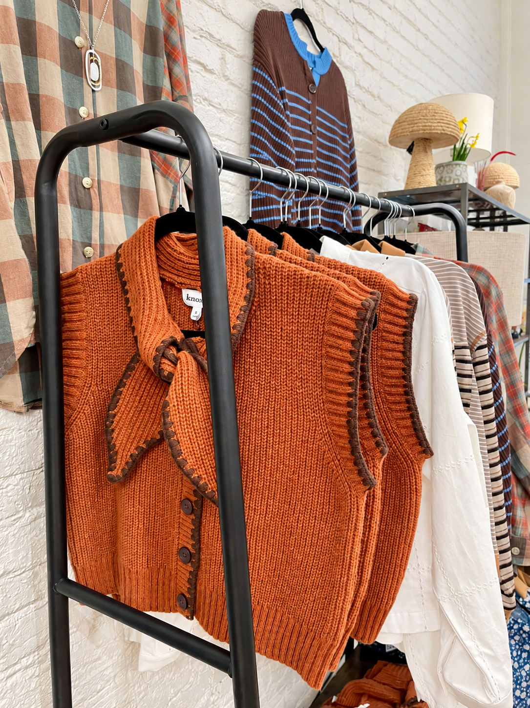 Discover cozy fall fashion at Decorate Indy, featuring the rust knit sweater vest, soft blouses, pla 