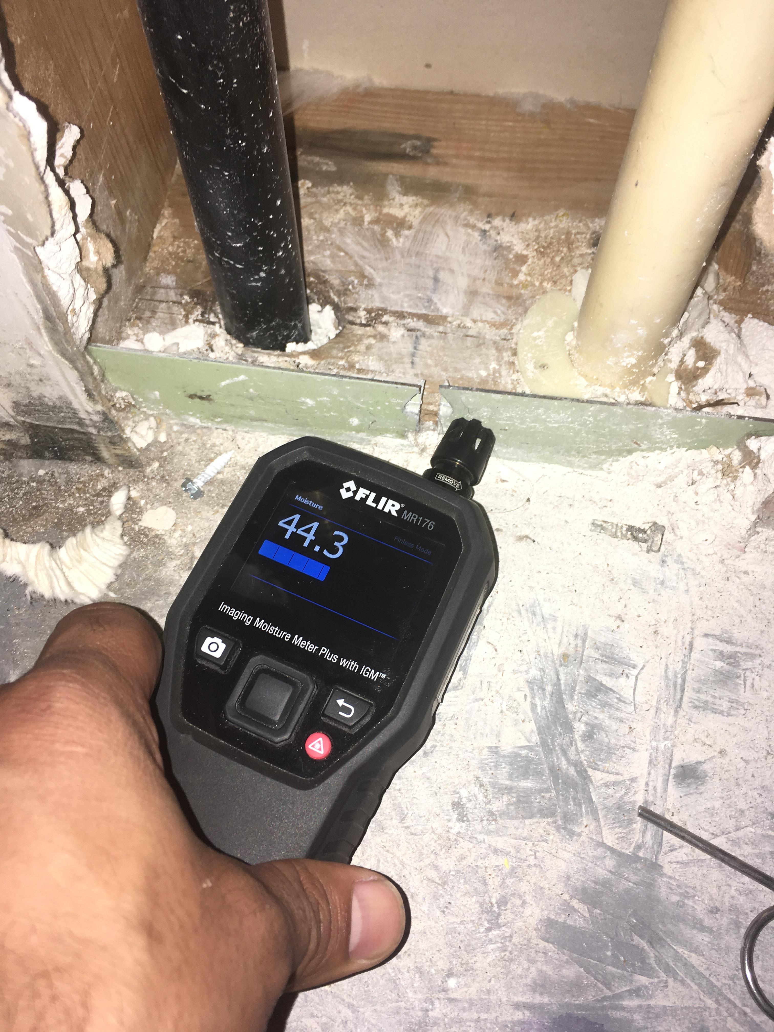 Moisture meter indicating there is water underneath this floor.